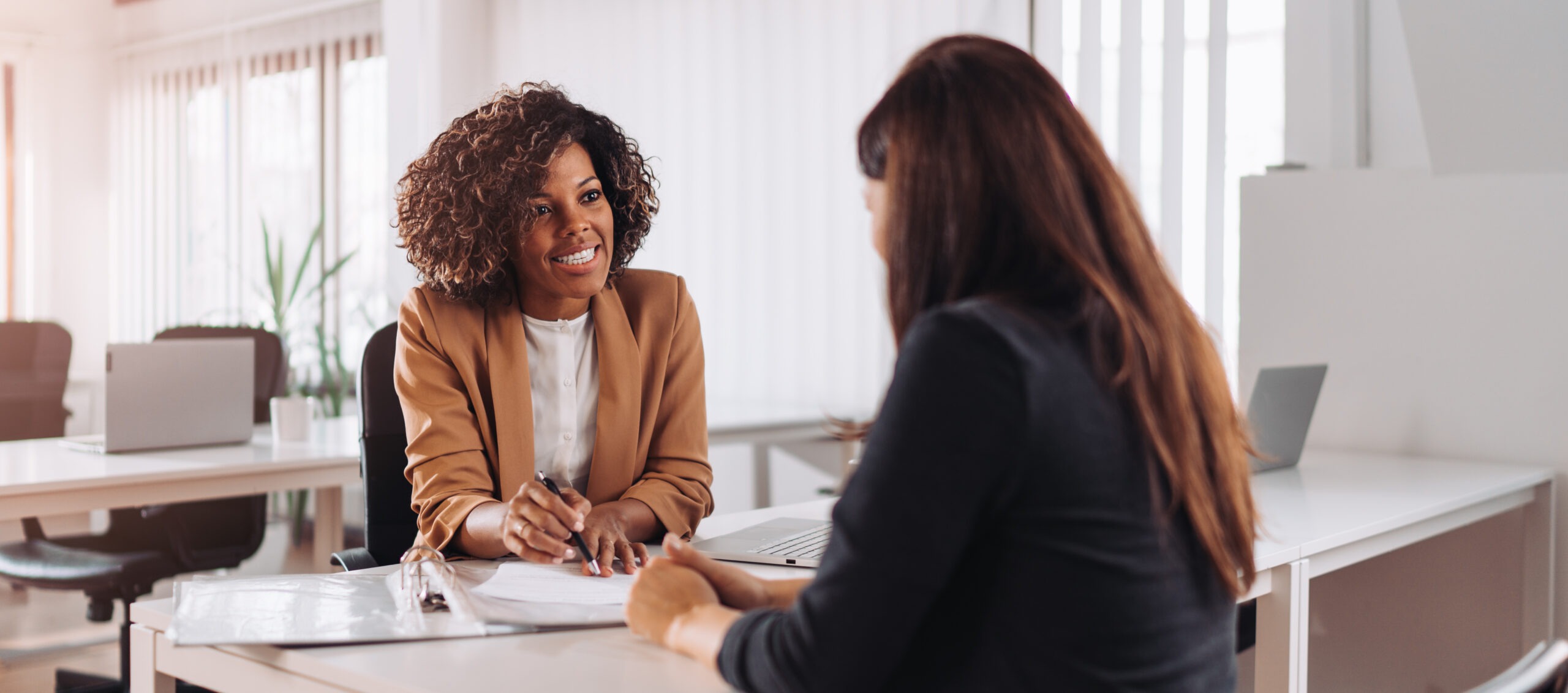 Woman consulting with a female financial manager at the bank; Shutterstock ID 1784866628; purchase_order: Limited 7/23/21